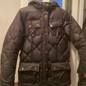 Barbour jacka  - En svart barbour jacka med äkta dun, avtagbar luva, saknar ett skärp, använd en säsong, storlek 36, Säljer för 1300 kr, priset kan diskuteras, köparen står själv för frakten