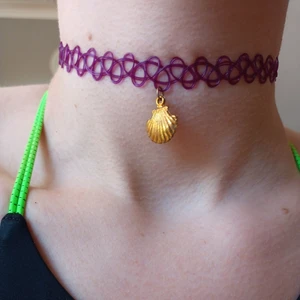 Lila choker med snäcka. FRI FRAKT - Lila choker med snäcka. Samfraktar gärna, vid köp av fler än två smycken får du den billigaste gratis. Fri frakt! 