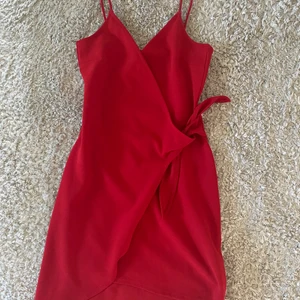 H&M röd klänning - En jättefin klänning som tyvärr är för liten för mig. Den är endast använd 1 gång och är därför i ett väldigt bra skick. Storleken är 32 och jag brukar ha 36, men jag får på mig den så den är ganska stor i storleken. Tveka inte att höra av dig!