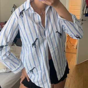 Randig skjorta - Randig skjorta med broderade giraffer från Zara, så fin på stranden över bikinin eller till shorts!🤍 fint skick, storlek Xs men passar även S och liten M