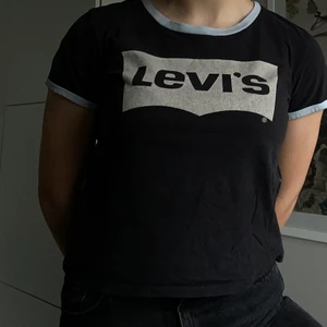 Levis t-shirt  - En fin Levis tröja i bra skick med vita muddar vid armen och halsen. Lite kort i modellen med en liten urringning. Köparen betalar för frakten🥰