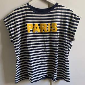 Blå-vit randig t-shirt från H&M, ”PARIS” i gult. Väldigt lite använd!😍 Storlek M, normal i storlek💞
