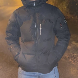 Sail racing Antarctica puffer  - Tjock dunjacka med med äkta dun. Passformen är Storlek S .jackan är samt vattentät för att vara dun så den klarar av en del regn. Jag har haft jackan ett år men har mestadels hängt på en galge. Observera att jackan inte säljs längre och den är köpt för 3000 nypris.