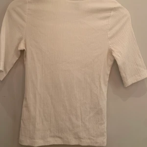 Basplagg, polo - Vit enkel, kortärmad polo i tunnare material 