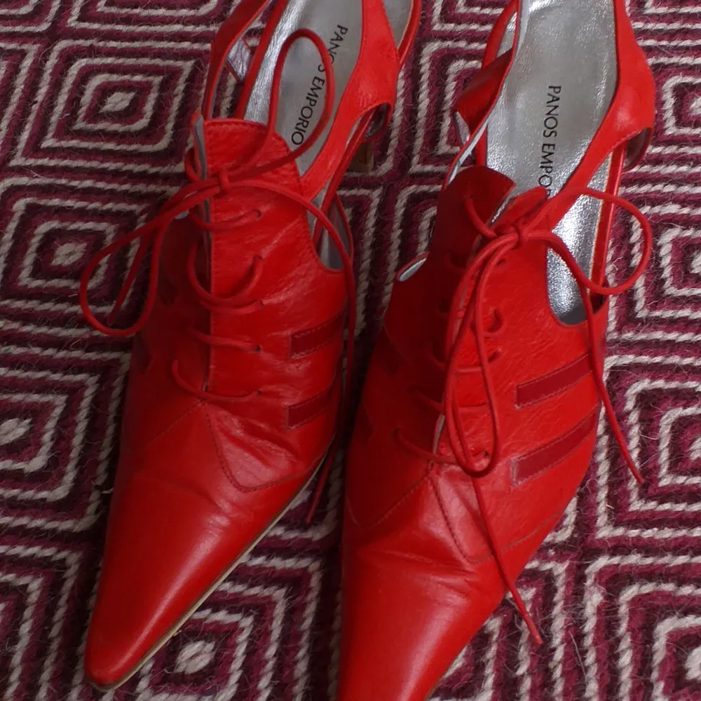 Ett par italienska röda sandaletter i skinn från Panos Emporio stl. 38. Vackert silvrigt skinn på insidan. Har används sparsamt. . Skor.