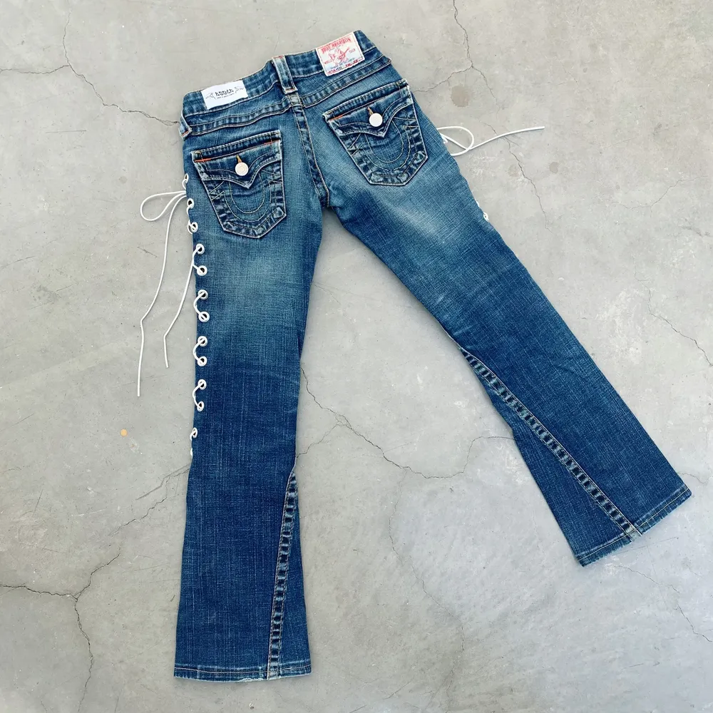 True Religion secondhand-jeans med vit snörning. Designade av Ezzie i samarbete med Ebba Martin. (Shipping only within Sweden). Jeans & Byxor.