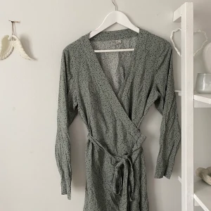 Grön omlott klänning - Grön omlott klänning från hm i strl 44. Det går dock att ändra storleken drastiskt då den går omlott och man knyter den själv.