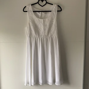 Vit klänning från Vila - Vit klänning med spets på överdelen. Underdelen består av en underkjol som täcks med ett mesh-tyg. Dragkedja finns på sidan. Kan mötas upp i Göteborg/Nyköping alternativt skicka om kund står för frakt 🌼