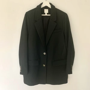 Oversized kavaj/ stl: M/ nyskick  - Svart kavaj i längre oversizedmodell från H&M säljes. Storlek M men passar även den som har storlek L. Kavajen har fickor framtill samt knäppning med två knappar. Endast använd en gång, så i mkt fint skick. Skriv gärna om du önskar fler bilder. :)