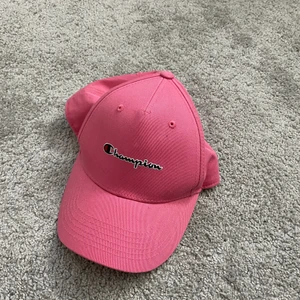 Keps - En rosa keps från champion. Man kan ha vilken huvud form som hälst finns ett kardborreband som man kan spänna själv. 