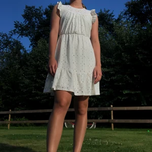 Söt klänning! - Söt klänning med volanger och hålmönster från Vero Moda!🤍 Köpt för 299:- och har bara använts en gång! Storlek XS men passar även S.