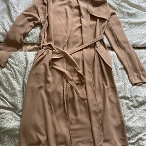 Kappa Xs (xs-L) - Beige kappa som är superfin På! Midjeskärp som man knyter så den passar i princip alla storlekar. Tunn så passar nu på sommaren. Passar till de beige byxorna i annan annons. Bud från 80;- jag bjuder på frakten 🥰🥰