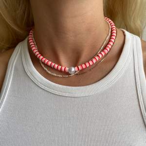 Handgjort halsband i en rosa kombination med en pärla i mitten. Förslutning bak med lås och tre ringöglor för justering. Finns fem st 💞💞💞 ENDAST ETT KVAR