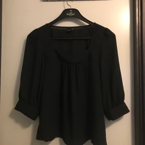 Gina Tricot blus storlek 38 - Supersnygg svart blus med korta armar. Perfekt nu till sommaren. Jättefint skick. 