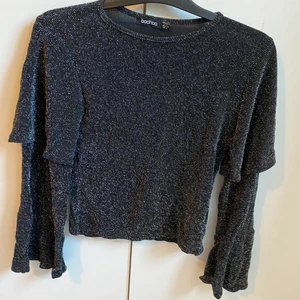 Glittrig topp - Topp i glittrigt material. Köparen står för frakt. 