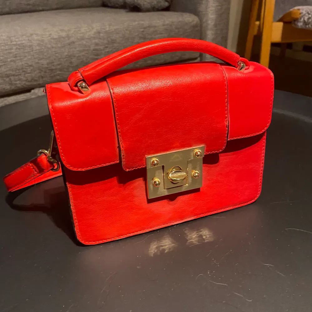 En röd liten handväska som passar perfekt till att göra en vanlig outfit lite coolare köpt på Lindex. Väskor.