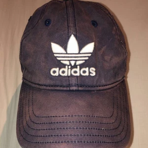 Svart/brun adidas keps - Mycket snygg keps som är använd väldigt få ggr. Färgen är svart men med solblekta detaljer från fabrik. Man kan välja hur tajt den ska sitta så passar vem som helst.☺️