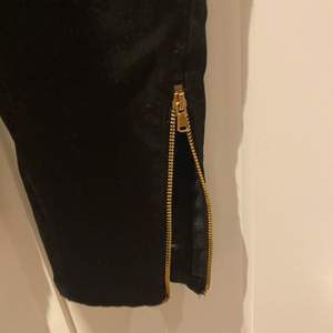 Ett par svarta skinny jeans med guldiga detaljer. Ganska stretchiga.
