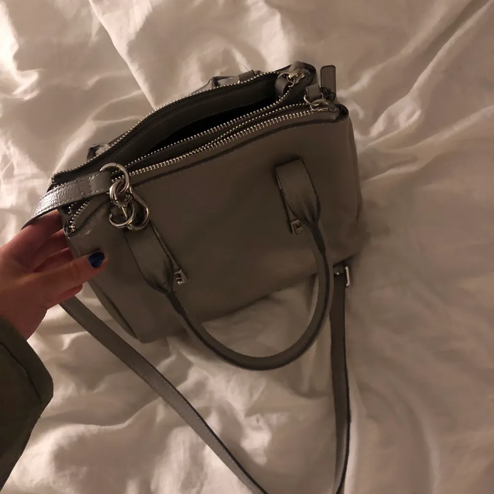 Säljer denna skit snygga grå ish väskan från zara! Man kan både ha den som crossover, hålla i den eller ha den på armen som jag gör på bilden , den är i bra skick och rymmer väldigt mkt, tre fack + liten ficka!! Möts upp eller fraktar 🥰. Väskor.