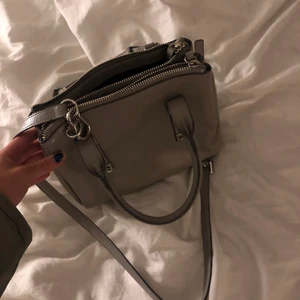Zara väska - Säljer denna skit snygga grå ish väskan från zara! Man kan både ha den som crossover, hålla i den eller ha den på armen som jag gör på bilden , den är i bra skick och rymmer väldigt mkt, tre fack + liten ficka!! Möts upp eller fraktar 🥰