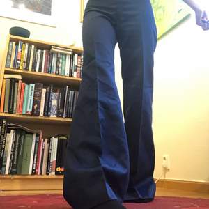 Handsydda blå kostymbyxor med låg midja och vida ben, passar toppen till en blus eller väst! Jag är 170cm och är 80cm runt höfterna samt 83 cm i Innerbenslängd! Dm om du har frågor😊 