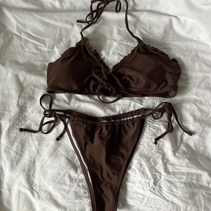 Brun justerbar bikini strl M - Aldrig använd, helt ny strl M, passar även S! Detalj mellan brösten och knytning, lite volanger. Inget spänne där bak men justerbar i nacken. Stretchig och uttagbara pads 💖 Justerbara trosor, kan dra ihop o få den smalare, även dra åt i banden i sidorna 💕