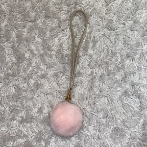 Stor nyckelring med rosa pompom - En glittrig guld nyckelband med en rosa pompom.💕 Perfekt till bilnyckeln.🚙 Säljer eftersom jag fick en ny i julklapp💓 Betalning via swish, endast seriösa köpare, tack❤️