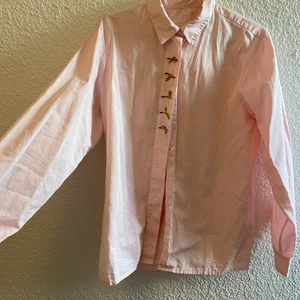 Skjorta med gräsänder - Ljusrosa vintageskjorta i storlek 44, men med dagens storlekar skulle jag verkligen säga att den e storlek 38. Mycket bra kvalitet, och väldigt bekväm. Jag har storlek M och tycker den e perfekt storleksmässigt. Den passar dock en med storlek S samt L, beroende på hur man vill att den ska sitta. 