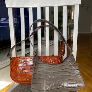 Väskor  - Två väskor i ormskinns imiterat material. Bra skick och rymmer mycket, bra till skola. 1 för 30 kr 2 för 50 kr 