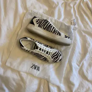 Sneakers från ZARA med zebramönster (äkta skinn!), storlek 38. Dustbag medföljer! Har ej rengjort så de kan nog bli som nya om man gör det 💍💍 Skosnörena är ej originalet utan de fick jag med ett par Eytys och de är helt oanvända 