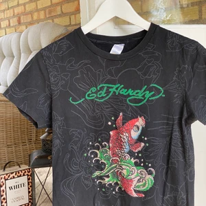 Vintage Ed Hardy t-shirt - Ett fint plagg från Ed Hardy med rhinestones på. I fint skick. Storleken är XL men jag skulle säga M! För fler bilder kontakta mig 👍 Mått: axlar 38 cm, bröstkorg 45 cm, längd 60 cm