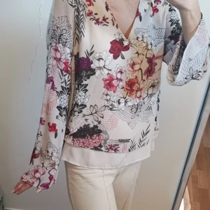 Beige blommig blus från kappahl st 36 - Beige blommig blus med Ida armar och V-neck. Från kappahl storlek 36.jättefin att ha till kostymbyxor och jeans. Kan lämnas i Jönköping annars står köparen för frakten. 
