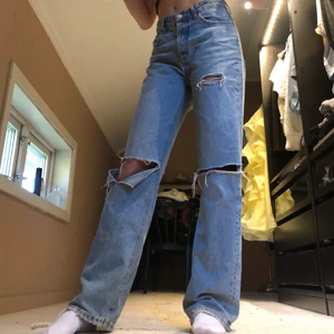 ZARA jeans - Snygga blåa jeans från ZARA i storlek 36😍. Utöver slitningarna på knäna och vid fickan har även jeansen konstgjorda slitningar vid anklarna för större känsla av street🛹