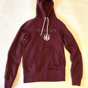 Vinröd Gant Shield hoodie. Bara använd ett fåtal gånger, mycket bra skick!