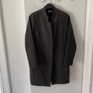 Mörkgrå Kappa - Fin höstkappa från italienska märket Kingkong. Stilren, klassisk modell. Tre dolda knappar och två fickor. 