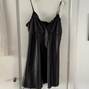 Silkig klänning - Ett silkigt o glansigt nattlinne som funkar som klänning också! 🖤💕 Så snygg till en vit t-shirt under och boots 😍 Axelbanden går att reglera, kanten nedtill är rå eftersom den är avklippt, men det ger bara mer charm 🤩🌟 Annars i fint o helt skick, inga fläckar! Storlek M-L, funkar på 40-44 🌟✨ Rosett som kan knytas mellan bysten ❤️