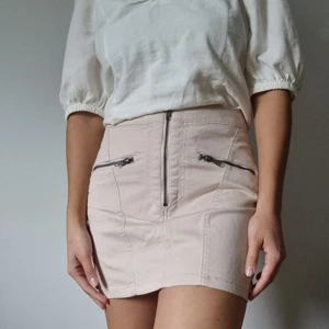 Minikjol, HM (strl 36) - Puderrosa minikjol från HM i storlek 36 (passform S), aldrig använd med prislapp kvar! OBS fickorna är äkta