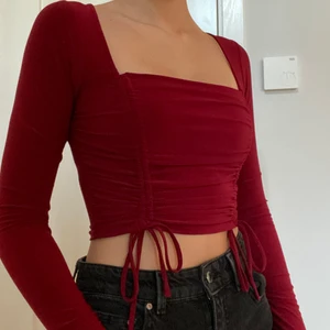 Superfin och skön vinröd topp  - Väldigt fin långärmad vinröd topp med snörning nertill. Passar S. Köparen står för frakten. 