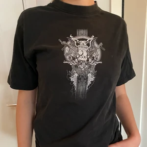 Second hand t-shirt med coolt tryck - Svart tröja köpt second hand. Snyggt tryck på framsidan. Storlek L men skulle säga att den är S. Köparen står för frakt. 