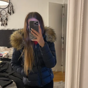 Rockandblue vinterjacka  - Rockandblue vinterjacka, mörkblå, väldigt varm, kort modell. Den är i storlek 38 men jag skulle säga att den är liten i storlek. Pälsen på luvan är inte äkta. 