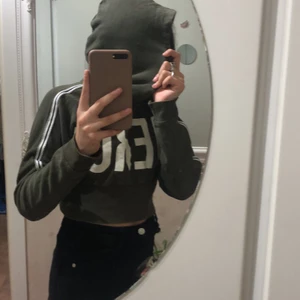 S - Har kristaller på armarna det är en mörk grön magtröja 