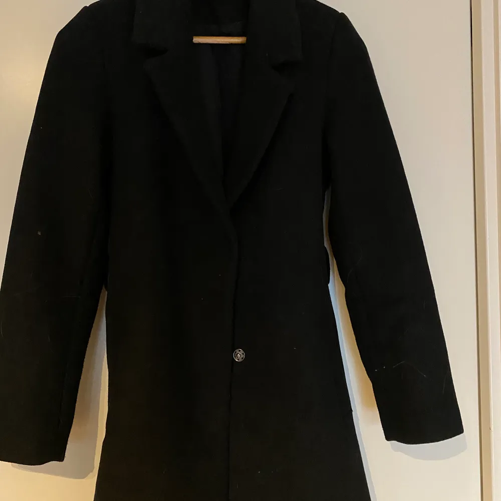 En svart kappa från H&M använd 2 gånger ungefär, säljer på grund av för liten. Storlek XS.. Jackor.