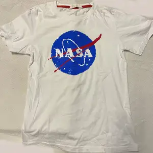 Vit t-shirt med NASA tryck i paljetter som är vändbart. Ev frakt betalas av köparen. 