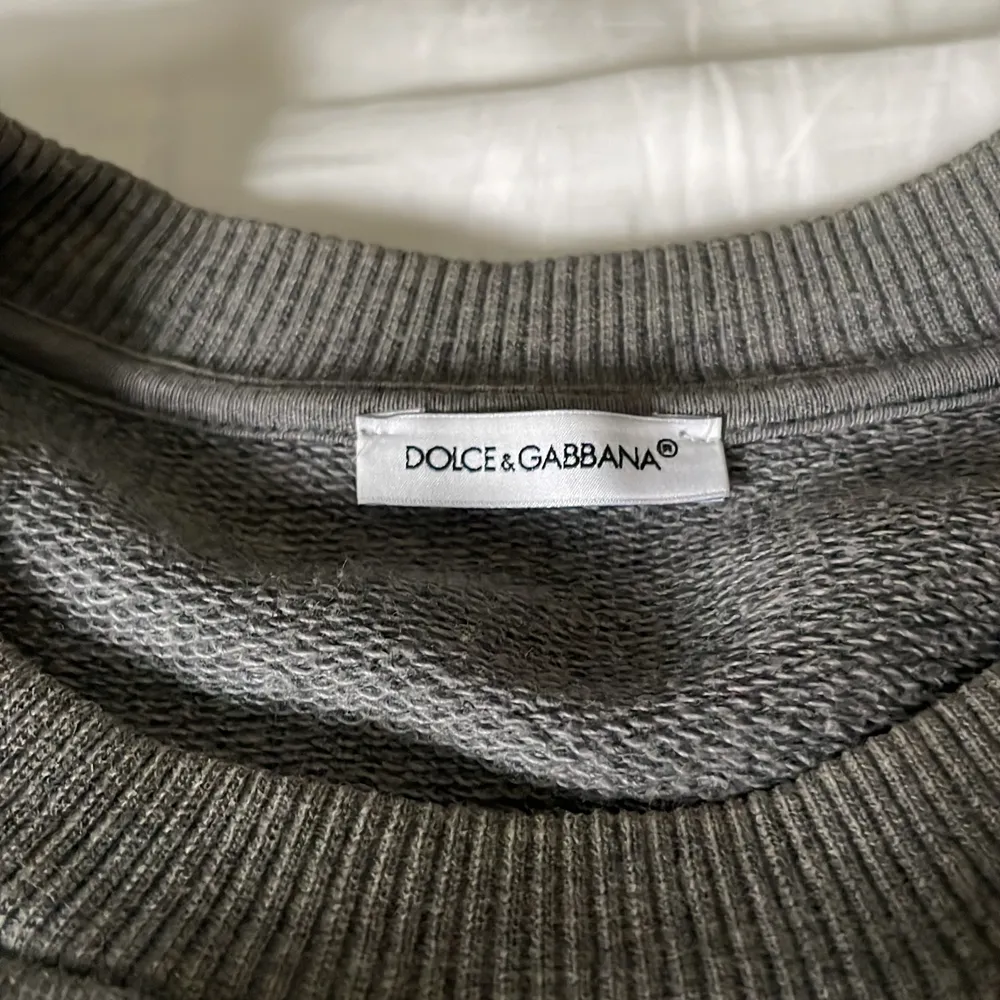 Grå Dolce&Gabbana tröja utan skador och väldigt fint skick, storleken passar barn 12-14år.                                    Nypris:4000kr.                                                                      Pris:1200kr. Tröjor & Koftor.