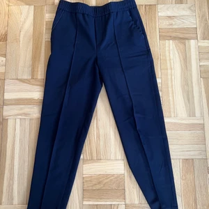 Kostymbyxor från Filippa K - Mörkblå kostymbyxor i fint använt skick med ett litet märke på ett utav benen. Nypris 1700kr. Strl. Xxs