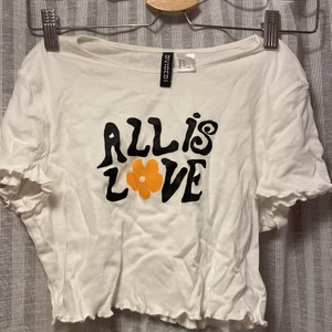 T-shirt HM - Jättefin ”all is love” T-shirt från HM som tyvärr inte har kommit till användning och är helt oanvänd. Köptes i somras. Inga defekter och jättefint. Köpare står för frakt, kan frakta både som brev eller spårbart. Skriv vid frågor 🥰
