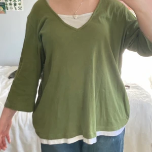 Grön tröja med vita detaljer - Jättesöt grön tunika i bella swan stil! Tre kvarts ärmar. Det vita är en del av tröjan så du behöver inte ha något under! Säljer för att den är i fel storlek för mig :) i fint skick!