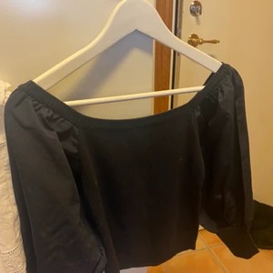 Svart blus  - Svart blus med off shoulder,fin i tyget och använd ett fåtal gånger 