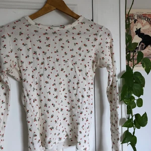 Topp med rosor från Brandy Melville - Supergullig trendig topp från Brandy Melville och väldigt sällan använd därav fint skick! 🌹 Jättegulligt mönster med små rosor på. Storleken är one-size men skulle säga det är en XS-M beroende på hur man vill den ska sitta då den är stretchig. Själv är jag en M. Köparen står för frakten!❤️
