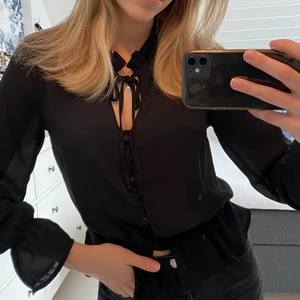 Svart blus  - En svart jätte gullig blus från GinaTricot! Knappar och fina volanger. Aldrig använd. Storlek 34 men passar även för storlek 36 